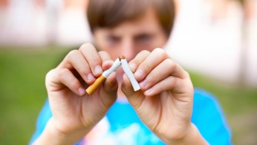 Young boy breaks a cigarette. Selective focus.